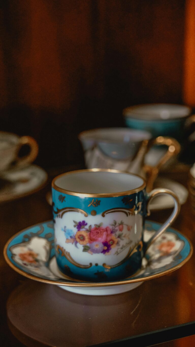 Close-up of a decorative hand-painted porcelain teacup and saucer with floral design.